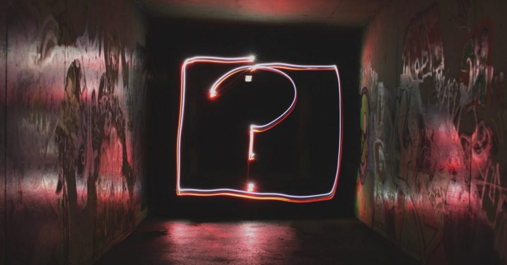 image description: neon questionmark on a black background