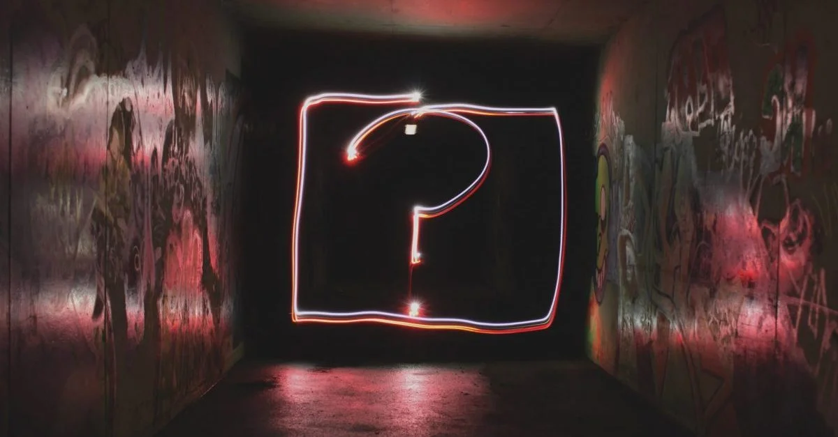 image description: neon questionmark on a black background