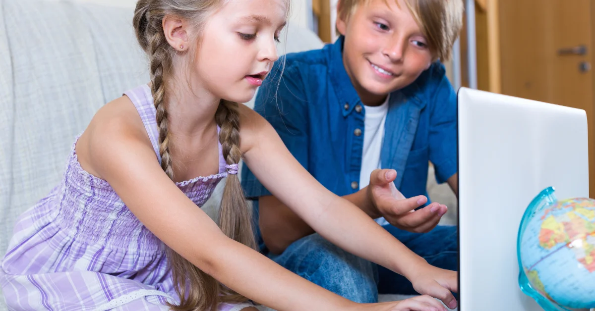 the childrens code - two children looking at a laptop