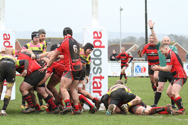 group of people playing rugby in red and black kits